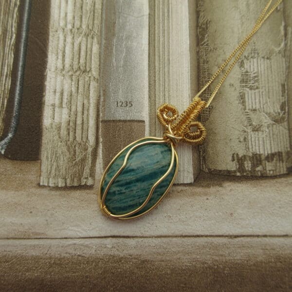 Pendant with green oval amazonite gemstone wire wrapped with gold plated wire and hanging from 18 inch gold plated fine curb chain
