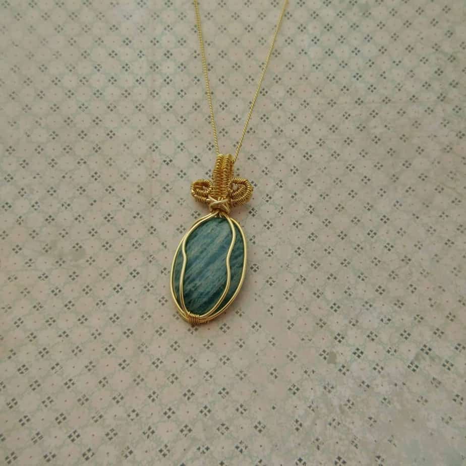 Pendant with green oval amazonite gemstone wire wrapped with gold plated wire and hanging from 18 inch gold plated fine curb chain
