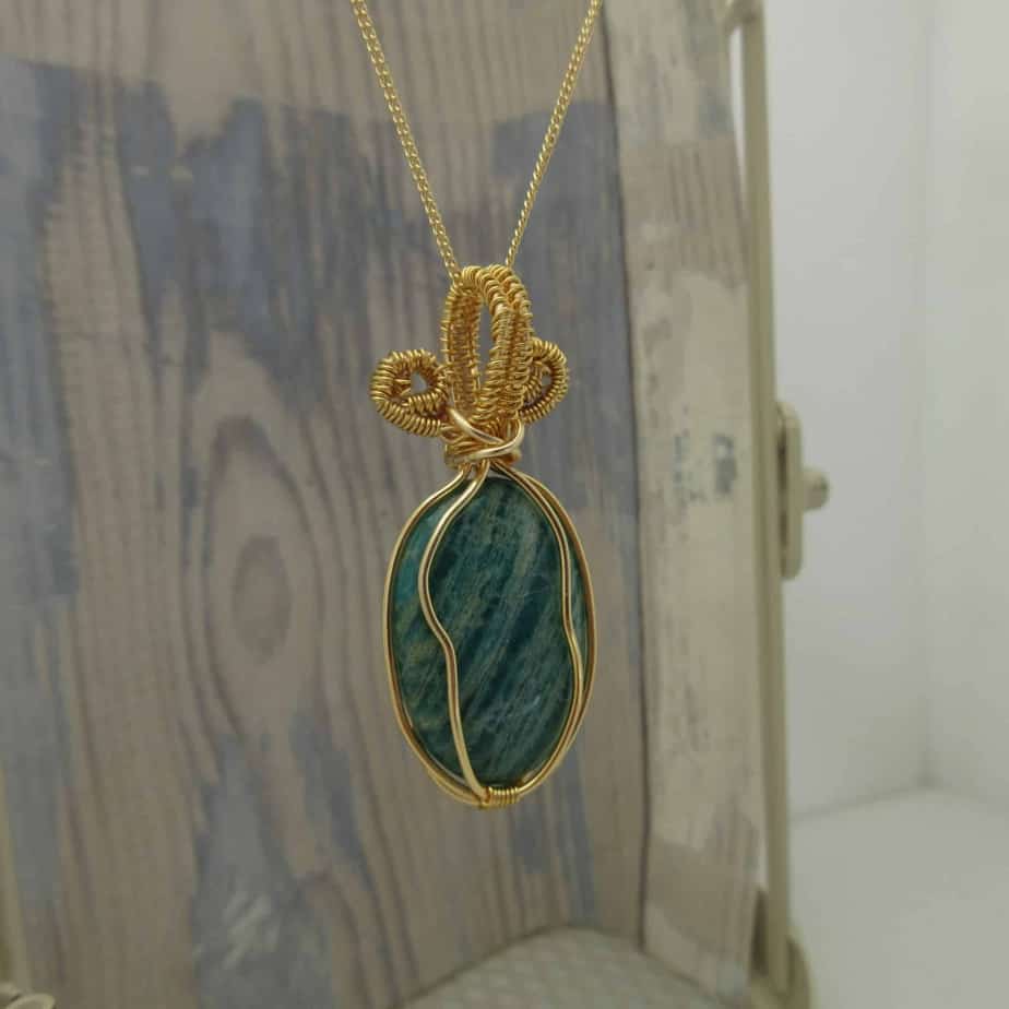 Pendant with green oval amazonite gemstone wire wrapped with gold plated wire and hanging from 18 inch gold plated fine curb chain