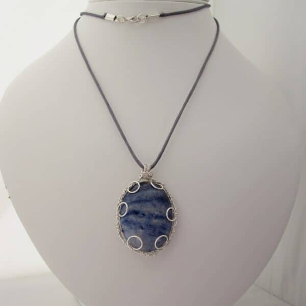 Large oval pendant featuring denim blue sodalite with a silver plated wire wrap. Hanging from grey cord 24 inches. One of a kind, designed and created in the Isle of Skye