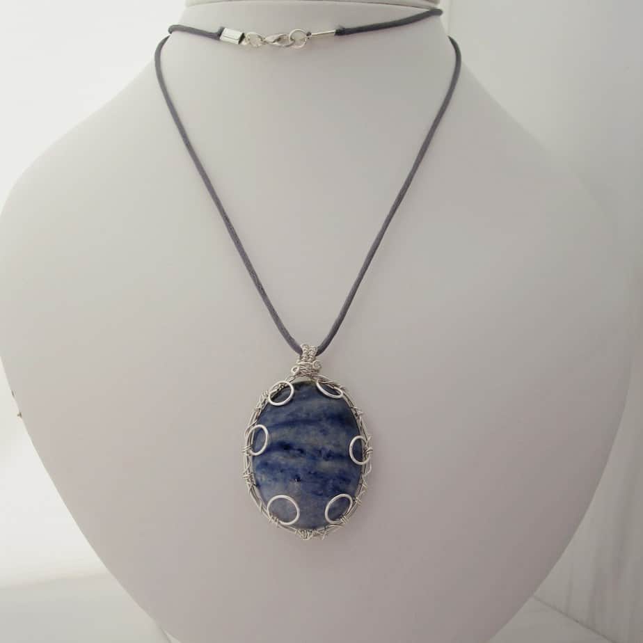Large oval pendant featuring denim blue sodalite with a silver plated wire wrap. Hanging from grey cord 24 inches. One of a kind, designed and created in the Isle of Skye