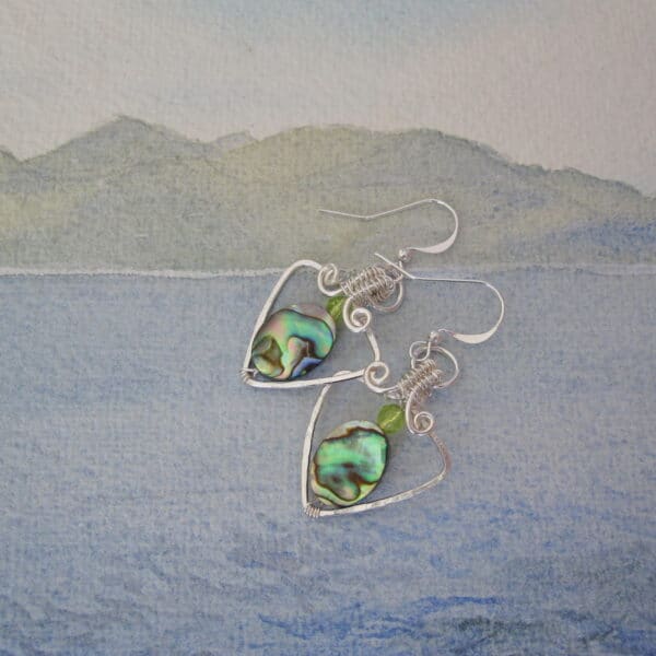 Silver plated earrings, triangular shape drop. With oval abalone shell and small faceted peridot above. One of a kind. Designed and created in the Isle of Skye by Indigo Berry