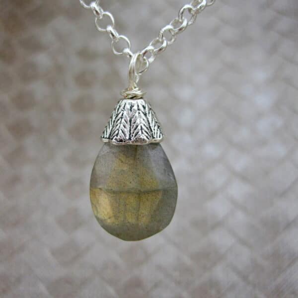 Designed and created in the Isle of Skye, this pendant necklace features a labradorite gemstone drop with silver plated bead cap. On 18 inch silver plated chain.
