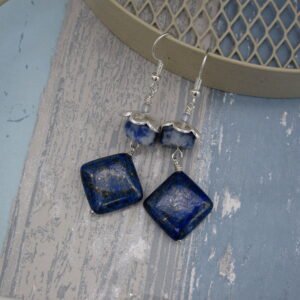 Drop Earrings with diamond shaped lapis lazuli and contrasting drum cut blue jasper. On silver plated ear wires with silver plated flower shaped bead cap.