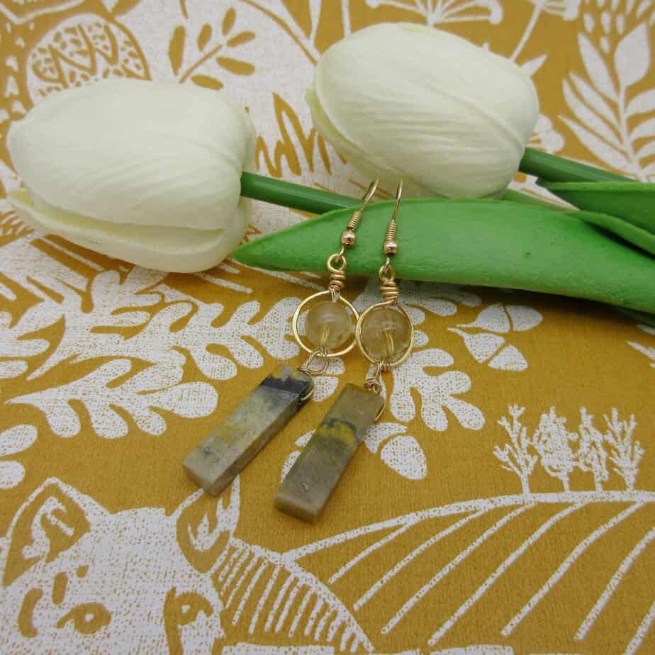 Drop earrings. Citrine round bead with halo of gold coloured wire. With column of bumblebee jasper hanging underneath. Gold plated ear wires.