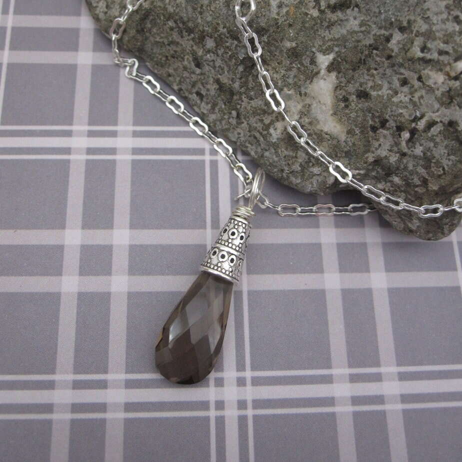 Smokey quartz pendant with silver plated celtic style bead cap and silver plated chain.