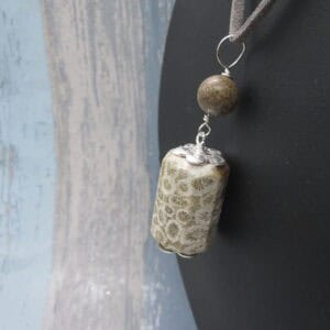 Fossil jasper pendant with simple silver plated bead caps and a single focal bead of deep brown jasper on a grey leather cord. Designed and created in the Isle of Skye.