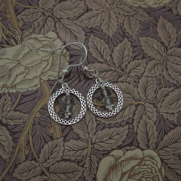 Earrings featuring a silver celtic knotwork circle with green amethyst drops inside. On sterling silver ear wires.