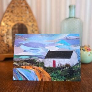 A photo of a greetings card featuring a collage of a small white building with a red door