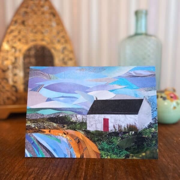 A photo of a greetings card featuring a collage of a small white building with a red door