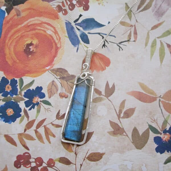 Silver plated wire wrapped column shaped labradorite pendant. Designed and created by Indigo Berry in the Isle of Skye