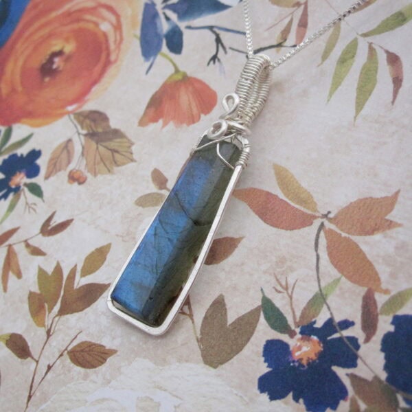 Silver plated wire wrapped column shaped labradorite pendant. Designed and created by Indigo Berry in the Isle of Skye