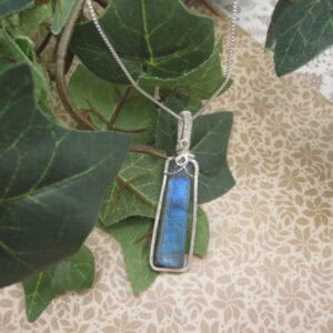 Silver plated wire wrapped column shaped labradorite pendant. Designed and created by Indigo Berry in the Isle of Skye