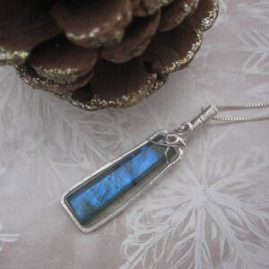 Silver plated wire wrapped column shaped labradorite pendant. Designed and created by Indigo Berry in the Isle of Skye